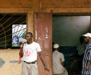 Calling people to a community rights meeting in Rogbangba, Sierra Leone.
