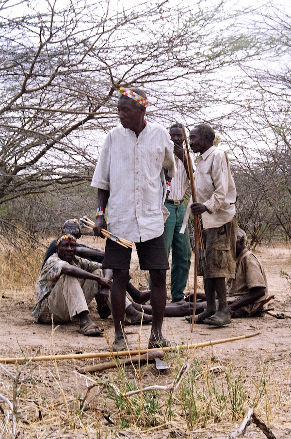 Hadza men prepare traditional hunting equipment during a cultural event. © UCRT