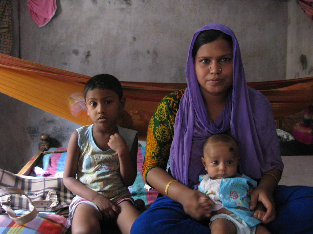 Shamimi and her children in her home in southwestern Bangladesh