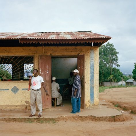 Opens popup gallery with A community member calls people to attend a community rights meeting organized by paralegals in the village school in Ro