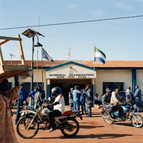 Opens popup gallery with The Sierra Leone national flag above the entrance to the divisional headquarters and central police station in Makeni.