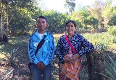Daw Nan Shan with paralegal Sai Sein Win Htun stand together on a farm